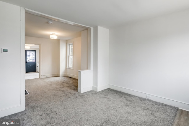 unfurnished room with carpet floors and baseboards