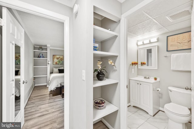 bathroom featuring a paneled ceiling, vanity, and toilet