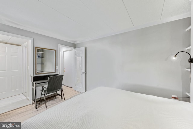 bedroom with hardwood / wood-style flooring and crown molding