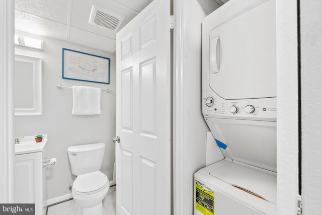 clothes washing area featuring stacked washer / dryer