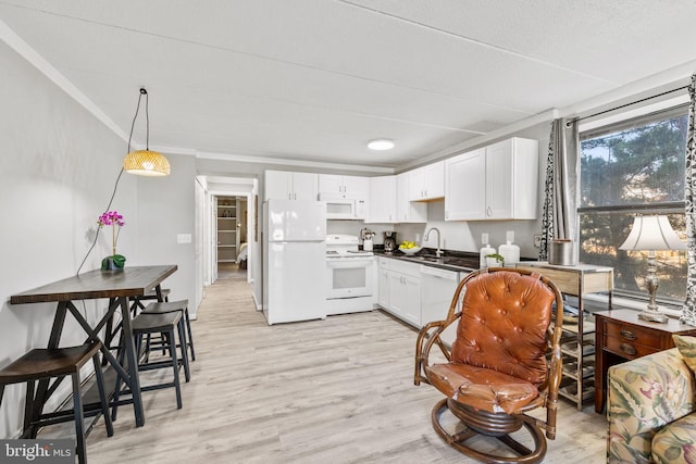 kitchen featuring white cabinetry, sink, white appliances, and light hardwood / wood-style floors