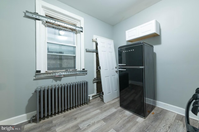 interior space with radiator and light wood-type flooring