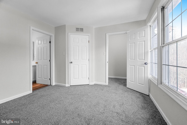 unfurnished bedroom with carpet floors and multiple windows