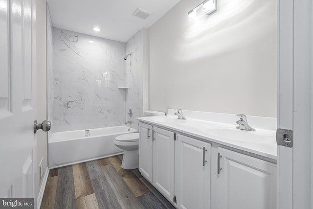 full bathroom featuring vanity, toilet, tiled shower / bath combo, and wood-type flooring