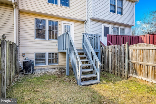 rear view of property featuring a wooden deck, central AC, and a lawn