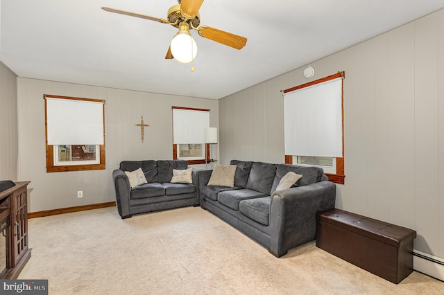 living room with a baseboard heating unit, light carpet, and ceiling fan