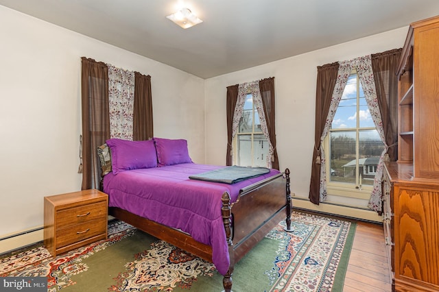 bedroom with hardwood / wood-style flooring and a baseboard radiator