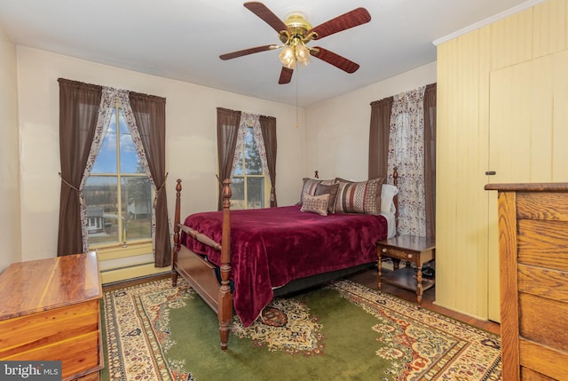 bedroom with ceiling fan, a baseboard radiator, and hardwood / wood-style floors