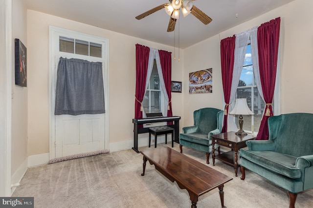 living area with ceiling fan and light carpet