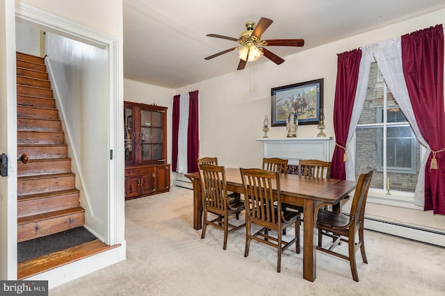 dining area featuring ceiling fan, light colored carpet, and a baseboard heating unit