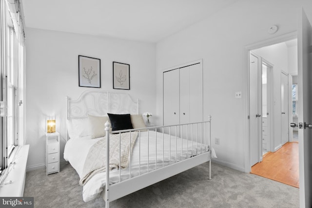 carpeted bedroom featuring a closet and baseboards