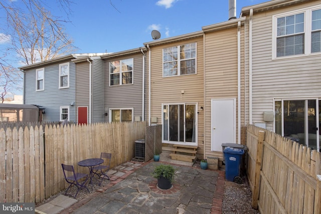 rear view of house with a patio, cooling unit, and fence