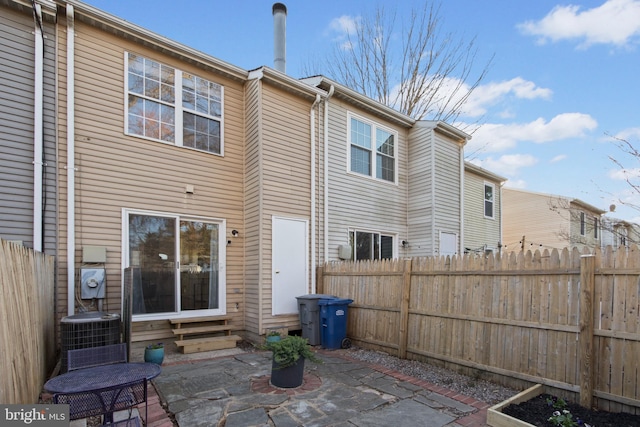 rear view of property with a patio, central AC, and fence