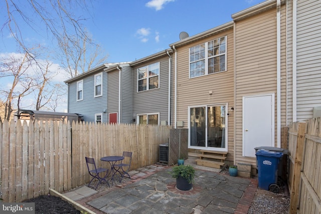 rear view of house featuring a patio, central AC unit, and fence