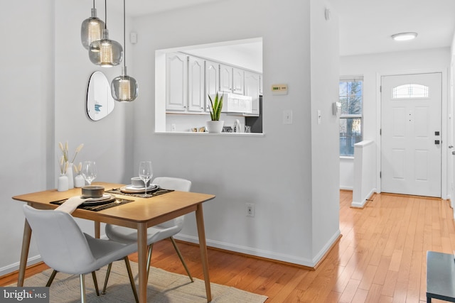 dining room featuring baseboards and light wood-type flooring