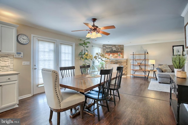 dining space with crown molding, a ceiling fan, baseboards, and dark wood-type flooring