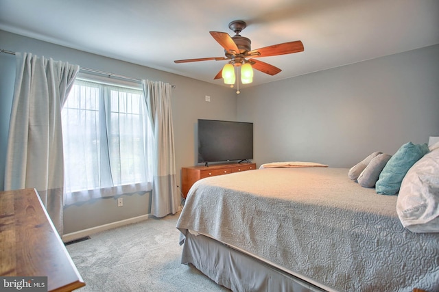 carpeted bedroom featuring baseboards, visible vents, and ceiling fan