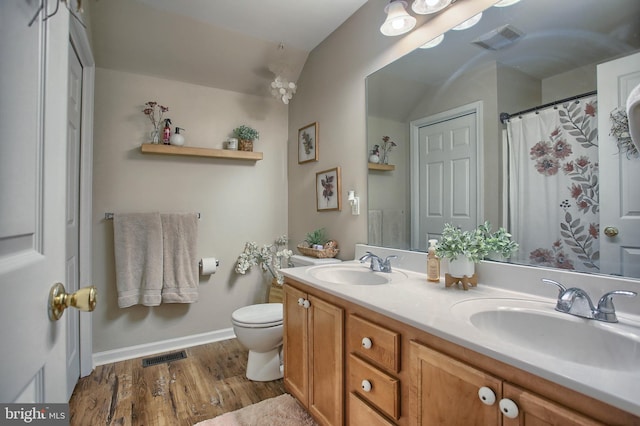 full bathroom with visible vents, a sink, and wood finished floors