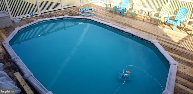 view of pool with a fenced in pool, a wooden deck, and fence