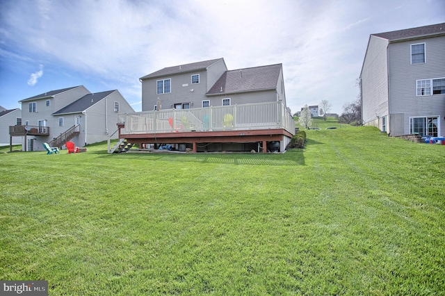 back of property featuring a lawn, a wooden deck, and a residential view