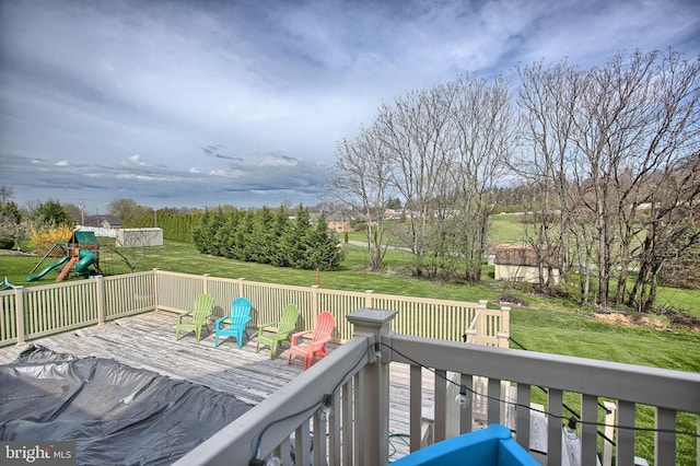 wooden deck featuring a lawn and a playground