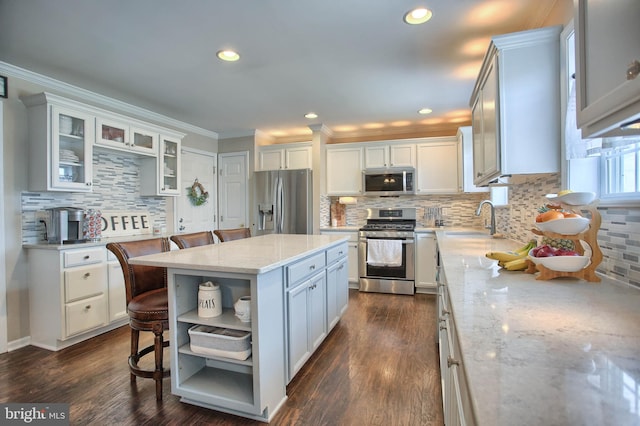 kitchen with white cabinets, open shelves, appliances with stainless steel finishes, a sink, and backsplash