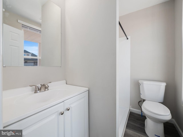 bathroom featuring hardwood / wood-style flooring, vanity, toilet, and walk in shower