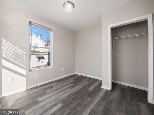 unfurnished bedroom featuring dark wood-type flooring and a closet