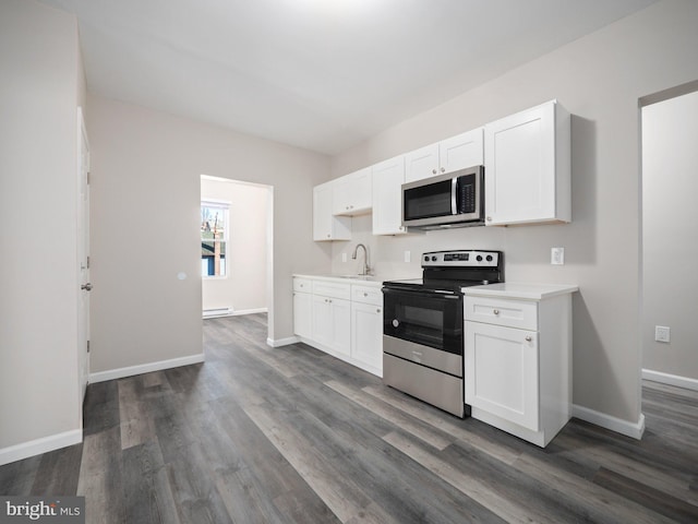 kitchen with white cabinetry, stainless steel appliances, dark hardwood / wood-style floors, and sink