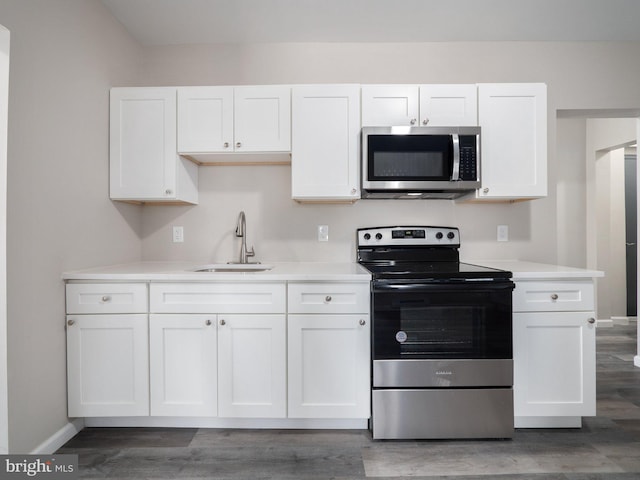 kitchen featuring white cabinetry, sink, stainless steel appliances, and dark hardwood / wood-style floors