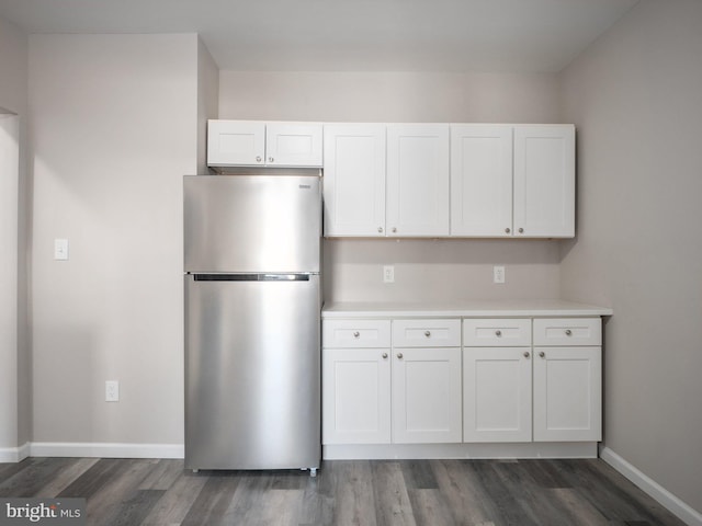 kitchen with stainless steel fridge, dark hardwood / wood-style flooring, and white cabinets