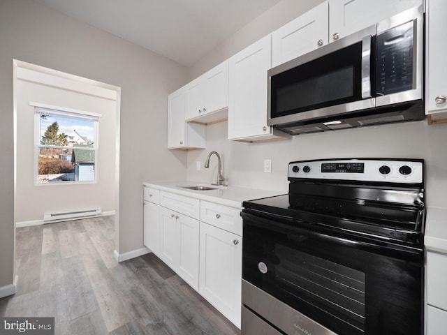 kitchen featuring a baseboard heating unit, appliances with stainless steel finishes, sink, and white cabinets