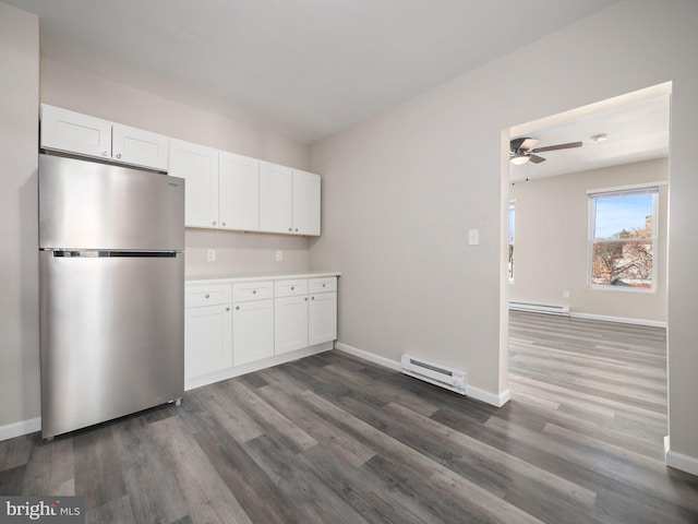 kitchen with white cabinetry, dark hardwood / wood-style flooring, stainless steel refrigerator, and a baseboard radiator