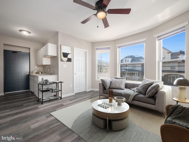 living room with ceiling fan, dark hardwood / wood-style floors, and sink