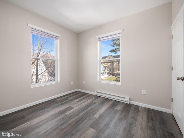 empty room featuring a baseboard radiator and dark hardwood / wood-style flooring