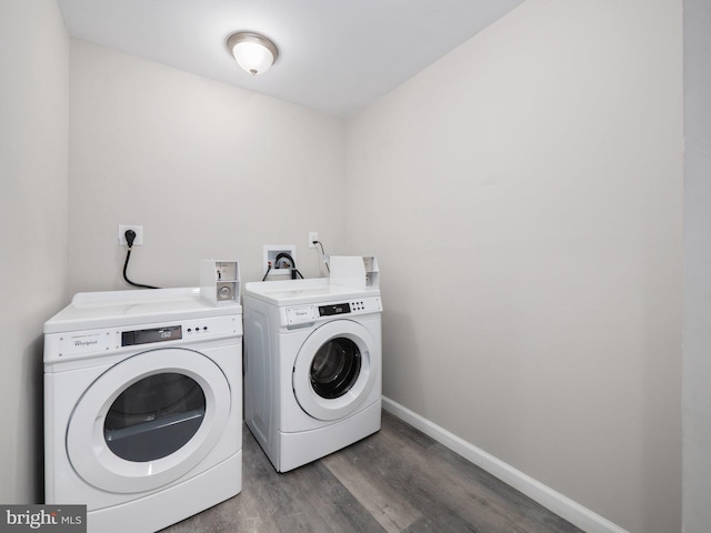 clothes washing area with washer and clothes dryer and dark hardwood / wood-style floors