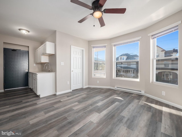 interior space featuring a baseboard radiator, dark hardwood / wood-style floors, sink, and white cabinets