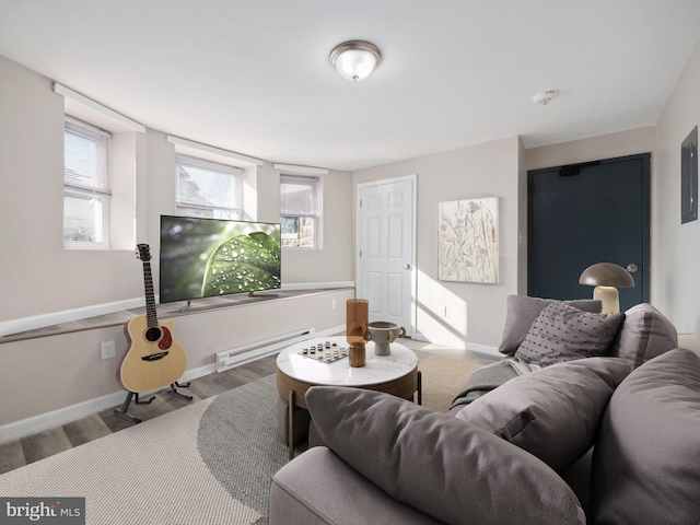 living room featuring hardwood / wood-style flooring, a healthy amount of sunlight, and a baseboard heating unit