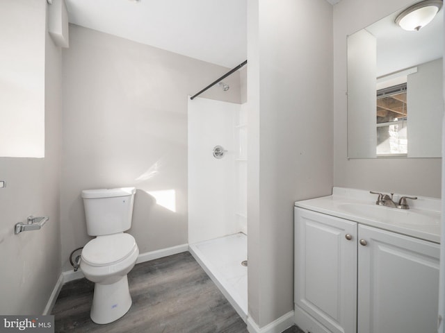 bathroom featuring vanity, hardwood / wood-style floors, toilet, and a shower