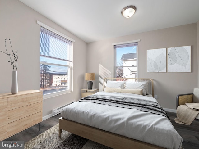 bedroom with a baseboard heating unit and dark hardwood / wood-style floors