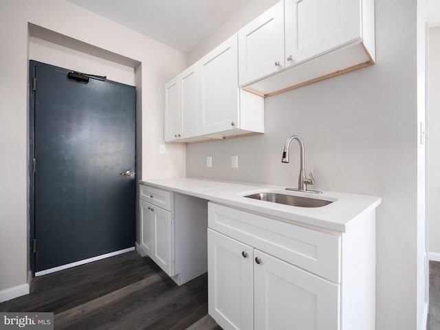 kitchen with dark hardwood / wood-style floors, sink, and white cabinets