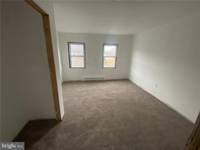 spare room with a baseboard heating unit and carpet flooring