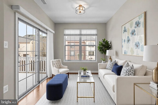 living room with a wealth of natural light and light hardwood / wood-style flooring