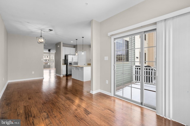 unfurnished living room featuring dark hardwood / wood-style floors and a chandelier