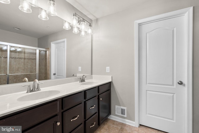 bathroom featuring tile patterned flooring, vanity, and a shower with shower door