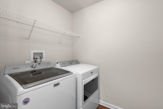 clothes washing area with separate washer and dryer