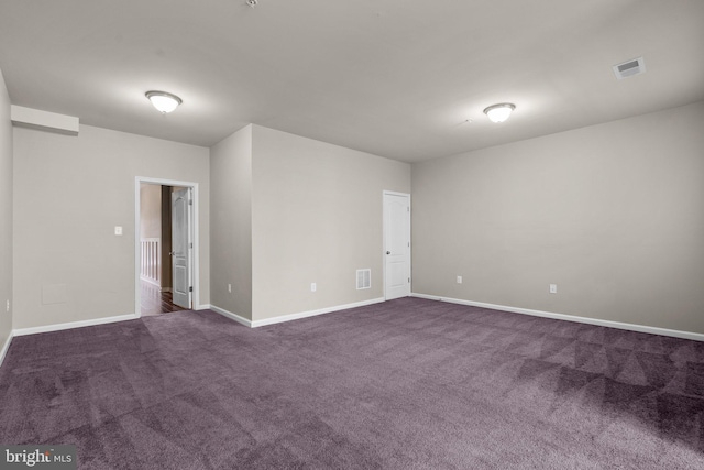 spare room featuring dark carpet