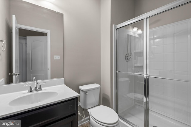 bathroom featuring walk in shower, vanity, and toilet