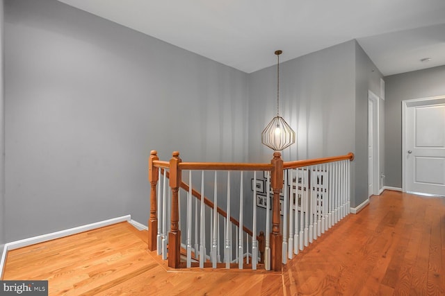 hall featuring a notable chandelier and hardwood / wood-style flooring