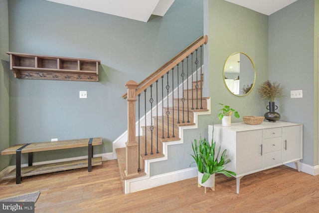 stairs featuring wood finished floors and baseboards